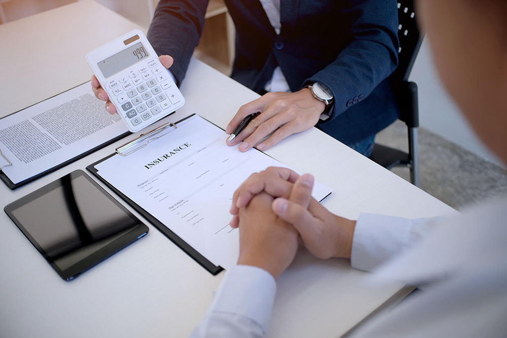 Sales manager giving advice application form document, considering mortgage loan offer for car and house insurance